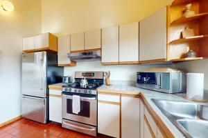 a kitchen with white cabinets and a stove top oven at Whispering Wave in Gualala
