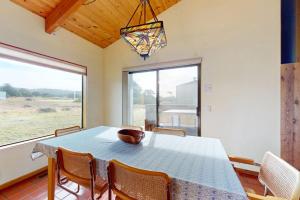 a dining room with a table and a large window at Whispering Wave in Gualala