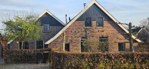 an old brick house with a fence in front of it at Spekenbrink-Haaksbergen in Haaksbergen