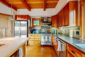 a kitchen with wooden cabinets and a stainless steel refrigerator at The Barn in Gualala