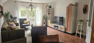 a living room with a couch and a tv at Spekenbrink-Haaksbergen in Haaksbergen