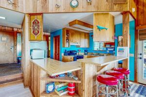 a kitchen with wooden cabinets and a counter with red stools at Clemons' Cottage in Sea Ranch