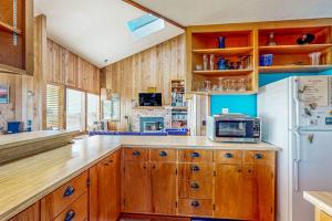 a kitchen with wooden cabinets and a white refrigerator at Clemons' Cottage in Sea Ranch +26 photos