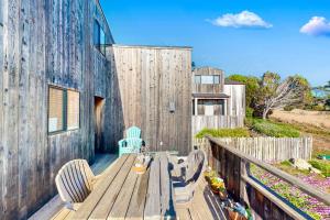 a wooden table and chairs on a wooden deck at Clemons' Cottage in Sea Ranch