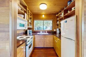 a kitchen with a stove and a white refrigerator at Redwood Grove in Sea Ranch