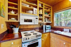 a kitchen with a stove and a microwave at Redwood Grove in Sea Ranch
