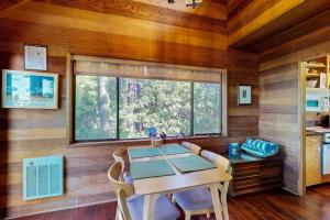 a dining room with a table and a large window at Redwood Grove in Sea Ranch +10 photos