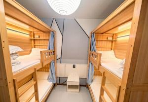 a room with two bunk beds and a desk at YangShuo Backpacker Hostel West Street Branch in Yangshuo