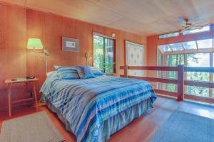 a bedroom with a bed with a blue comforter at The Redwood House in Fish Rock