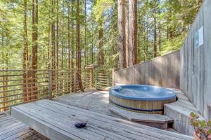 a hot tub on a wooden deck in the woods at The Redwood House in Fish Rock