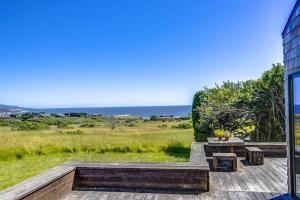 a patio with a table and a view of the ocean at The Glass House in Sea Ranch