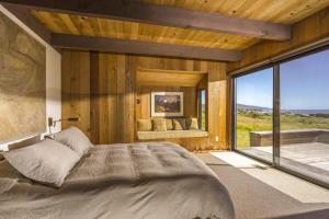 a bedroom with a large bed and a large window at The Glass House in Sea Ranch