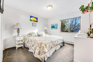 a white bedroom with a bed and a window at Cove House in Gualala
