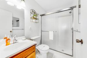 a white bathroom with a shower and a toilet at Cove House in Gualala