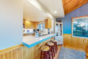a kitchen with a blue counter and stools in it at Eternal Equinox in Sea Ranch