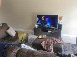 a living room with a couch and a flat screen tv at Crystal Self Catering 3 bedroom Villa in Swakopmund