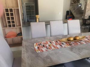 a dining room table with three chairs and a tableasteryasteryasteryasteryasteryastery at Crystal Self Catering 3 bedroom Villa in Swakopmund