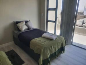 a bed with two pillows on it in a room with a window at Crystal Self Catering 3 bedroom Villa in Swakopmund