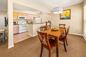 a kitchen and dining room with a table and chairs at Luxury Condo with Golf Course Views Pools & Resort Access in New Bern
