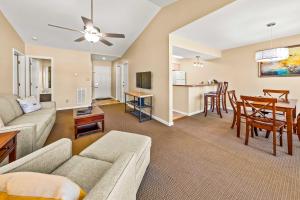 a living room with a couch and a dining room at Luxury Condo with Golf Course Views Pools & Resort Access in New Bern