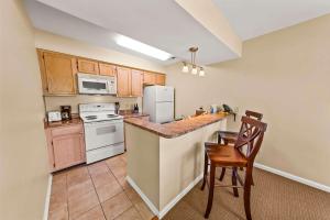 a kitchen with a white refrigerator and a stove top oven at Luxury Condo with Golf Course Views Pools & Resort Access in New Bern +23 photos