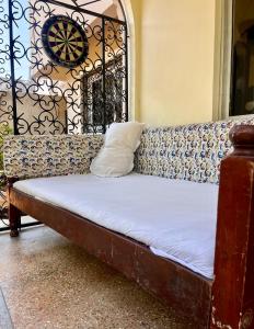 a couch with a pillow sitting on top of it at Akogo House - BnB , Hostel, Backpackers & Volunteer Center in Mombasa