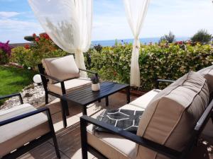 a patio with a table and chairs and the ocean at Sea La Sun, Green Coast in Palasë
