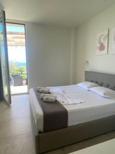 a bedroom with a bed with a view of the ocean at Sea La Sun, Green Coast in Palasë