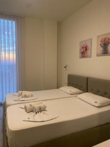a bedroom with two beds with towels on them at Sea La Sun, Green Coast in Palasë +8 photos