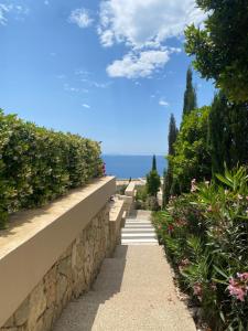 a stone wall with stairs leading to the ocean at Sea La Sun, Green Coast in Palasë
