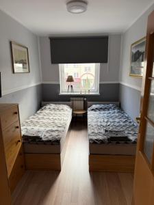 two beds in a room with a window at Apartament Aria in Ełk