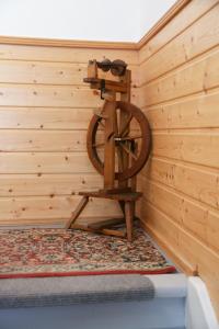 ein Holzzimmer mit einem Rad an einer Holzwand in der Unterkunft Antik Apartments Spreewald/Vetschau in Vetschau