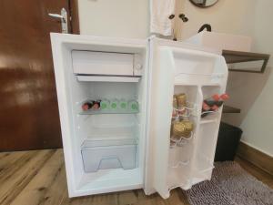 a white refrigerator with its door open in a room at REFUGIO Chacara ENTRE NÓS in Holambra