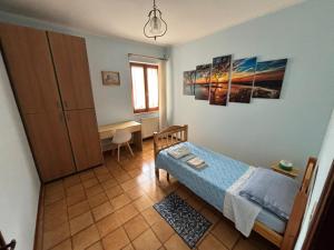 a bedroom with a bed and a desk and a window at Casa Pianforte - appartamento per vacanze in Bolsena
