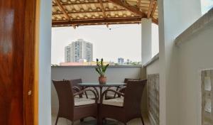 a balcony with a table and chairs and a window at Pousada Flor do Sol in Fortaleza