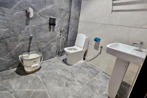 a bathroom with a toilet and a sink at TrueLife Nexus Suites in Tirupati