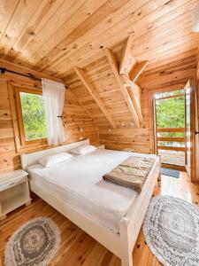 a bedroom with a bed in a log cabin at Guest house Mickovic in Žabljak