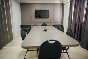 a conference room with a table and chairs and a tv at Hospedare Hotel in Marechal Cândido Rondon