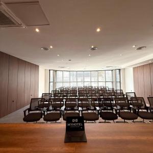 an empty room with a large lecture hall with chairs at MY HOTEL in Prizren
