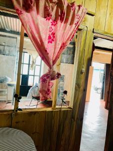 a room with a table with a pink curtain at Casa 74 hostel in Comitán