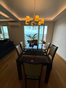 a dining room with a table with chairs and a chandelier at Tamariz Adventure - Sea View and Free Parking in Caniço
