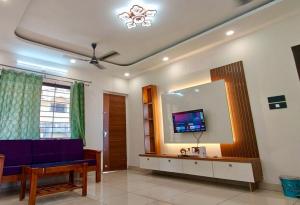 a living room with a blue couch and a large mirror at Sheetal Service Apartment in Mangalore