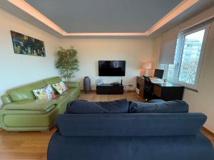 a living room with a couch and a flat screen tv at Tamariz Adventure - Sea View and Free Parking in Caniço