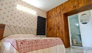 a bedroom with a bed and a bathroom with a shower at Sheetal Service Apartment in Mangalore +49 photos