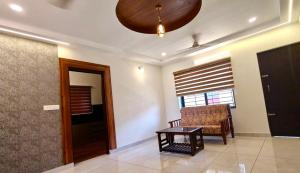 a living room with a chair and a table at Sheetal Service Apartment in Mangalore