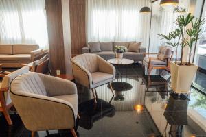 a living room with chairs and a couch and a table at Hospedare Hotel in Marechal Cândido Rondon