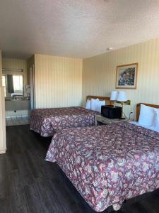 a hotel room with two beds and a window at Tree Inn & Suites Albuquerque in Albuquerque +2 photos