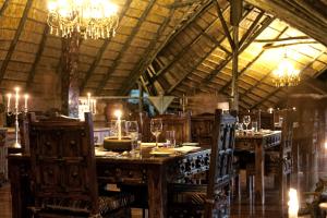 a dining room with a long table with chairs and a chandelier at Mbali Mbali Soroi Serengeti Lodge in Banagi