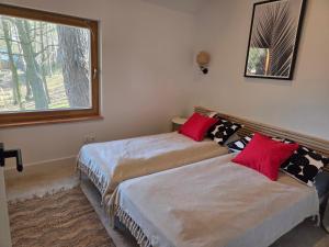 two beds in a room with a window at Naturelodge Kalbornia Mazury in Dąbrówno