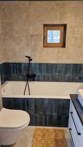 a bathroom with a tub and a toilet and a window at Naturelodge Kalbornia Mazury in Dąbrówno +13 photos